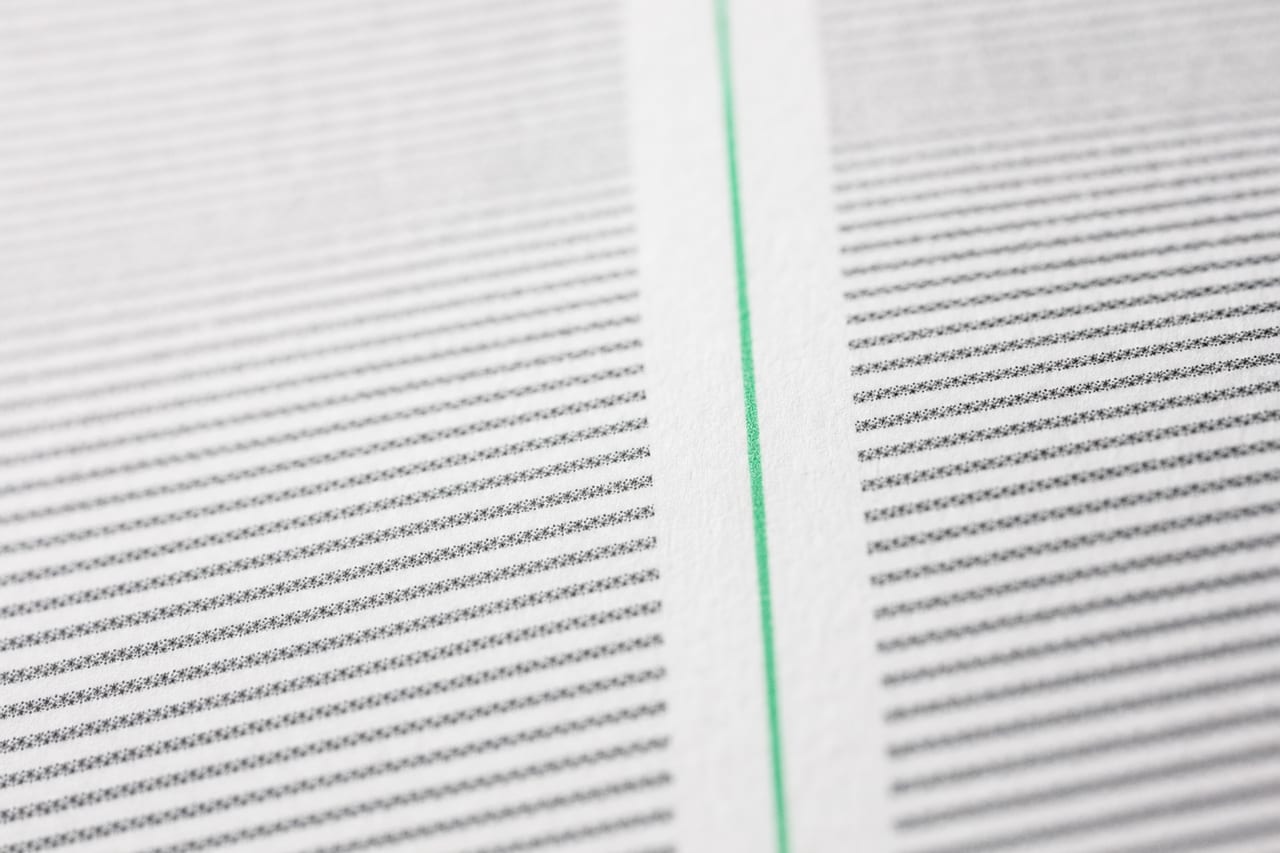 Nahaufnahme eines Kursblatts mit zwei parallelen Zahlenspalten; der schmale Zwischenraum in der Bildmitte ist über die ganze Länge mit einer dünnen grünen Linie markiert.